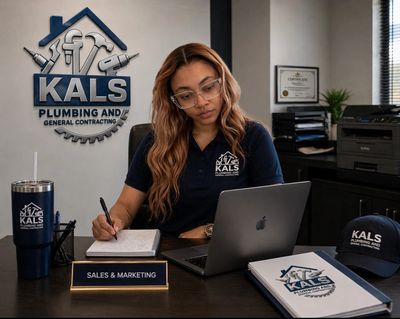 Woman working at a desk in a branded plumbing and contracting office.