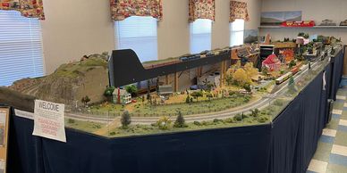 Detailed model train layout with landscape and buildings on display.