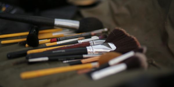 A collection of various makeup brushes laid out on a surface.