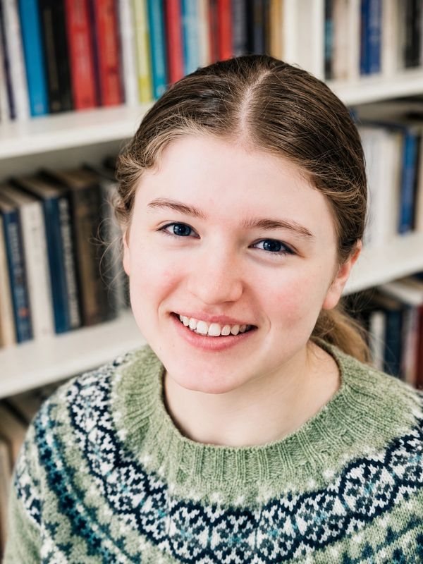 Smiling young woman in a patterned sweater.