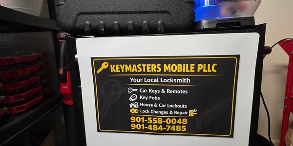 Mobile locksmith service advertisement with contact numbers.