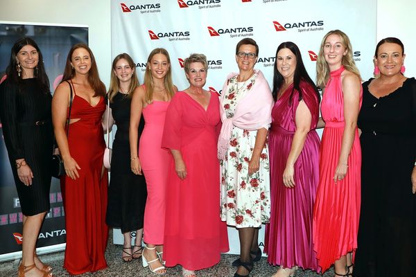 Group of nine women posing at a Qantas event.