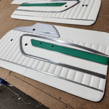 Two white car door panels with green and chrome details.