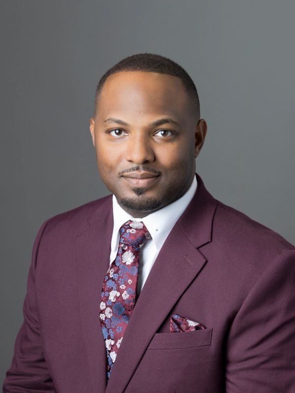 Professional man in a maroon suit with floral tie.