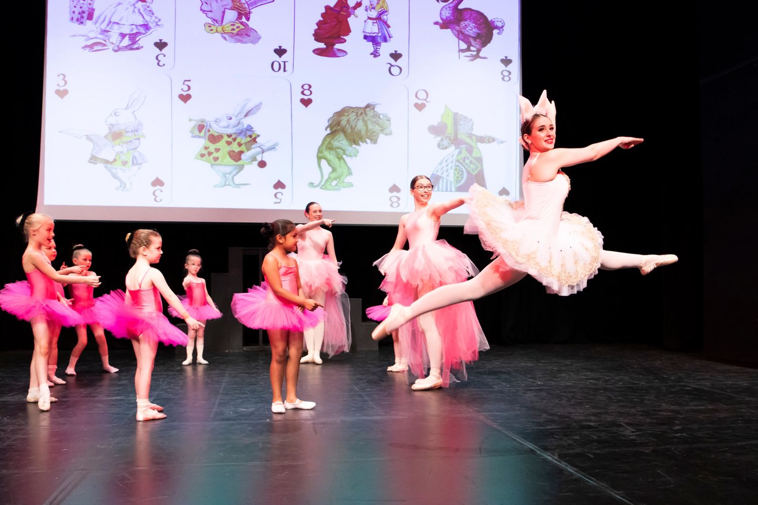 Teacher and her students on stage at a ballet event 