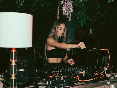 Beautiful female DJ in Miami gets the crowd moving with the top EDM tracks of the summer