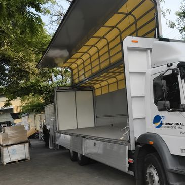 LKW mit offenem Dach in Lagerbereich.