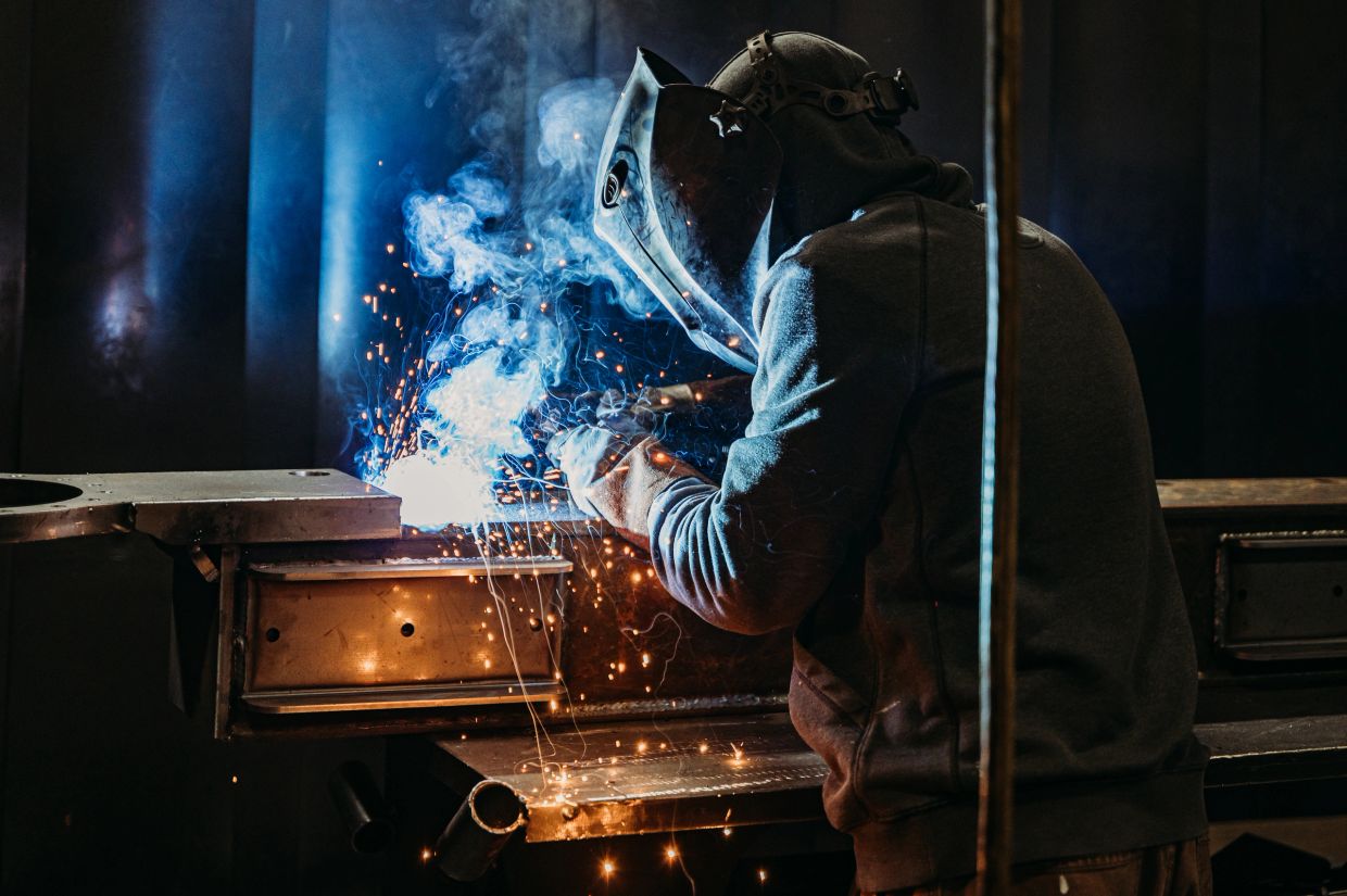 Person welding metal, sparks flying.