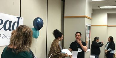 Dare to Lead participants standing and engaging in partner chats about the content