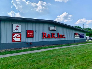 Exterior of R&R, Inc. building with truck brand logos on the wall.