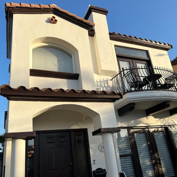 Two-story house with Mediterranean-style architecture and balcony.