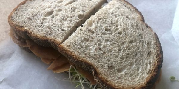 Close-up of a sandwich with whole grain bread and sprouts.