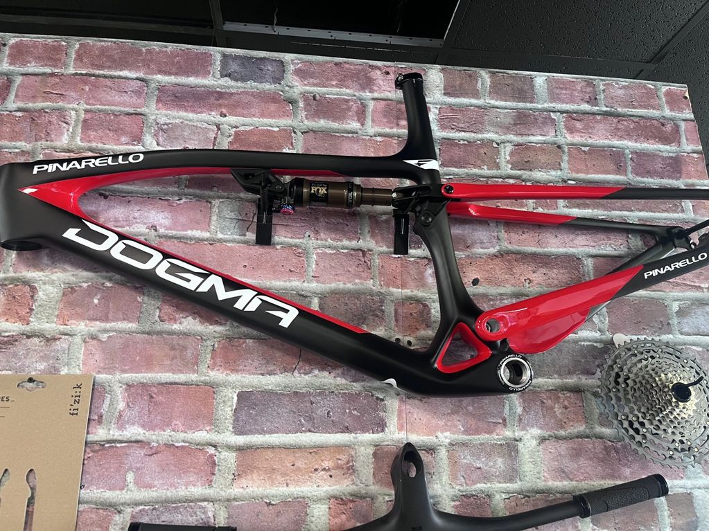 Pinarello Dogma bike frame against a brick wall.