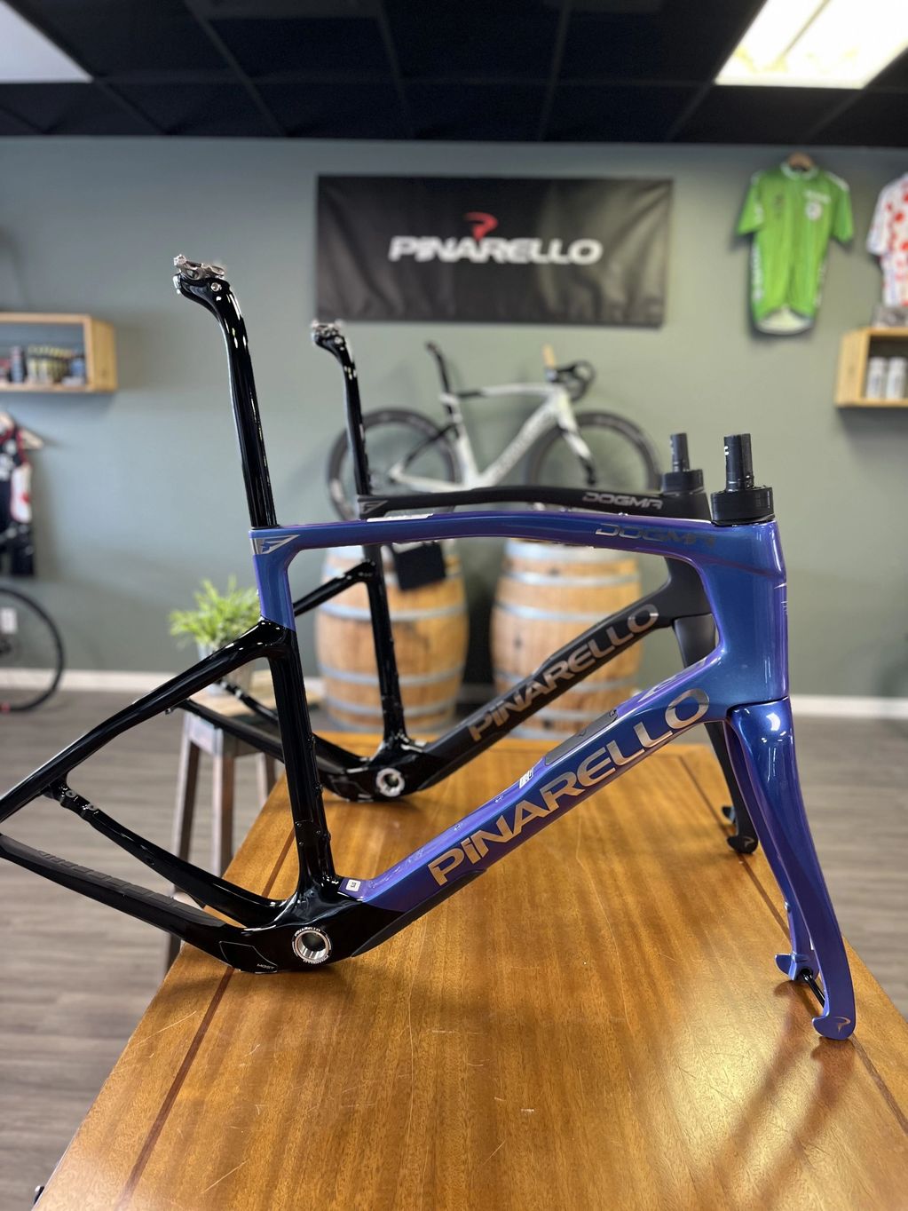 Two Pinarello bike frames on a wooden table in a showroom.