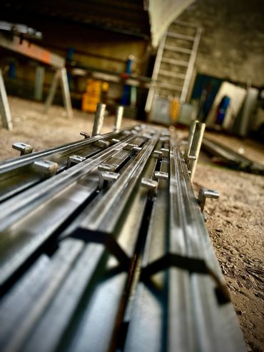 a stack of metal lengths with brackets welded on