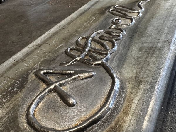 weld writing. a weld bead that forms the word Attwell, the business name