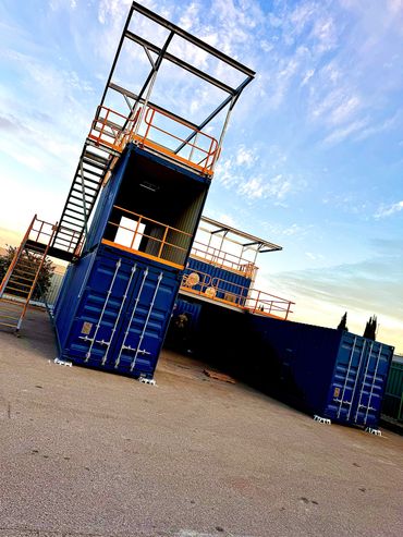 blue shipping containers stacked up on top of each other to form a training centre