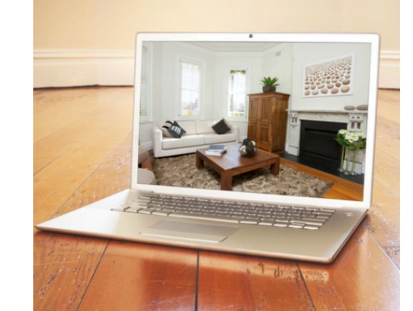 Laptop displaying a cozy living room with wooden furniture and modern decor.