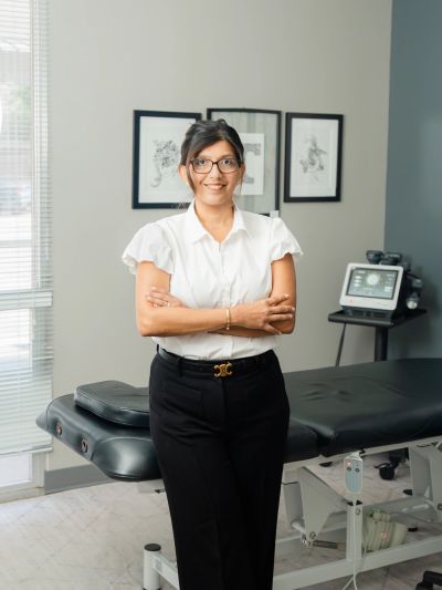 Confident woman standing in a medical or therapy room.