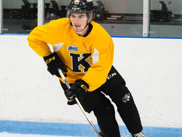 Hockey player in yellow jersey on ice rink.