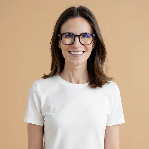 Smiling woman wearing glasses and a white t-shirt.