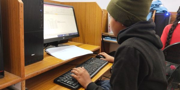A person using a computer in a cubicle workspace.