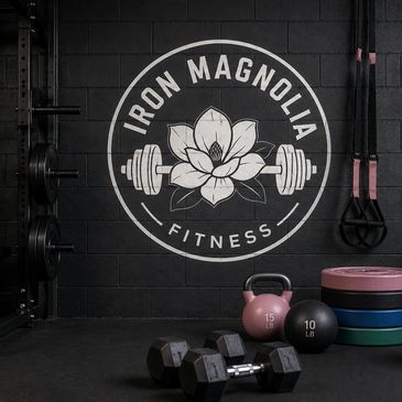Fitness gym logo with weights and equipment on a black wall.