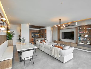 Modern open-plan living room with neutral tones and stylish lighting.