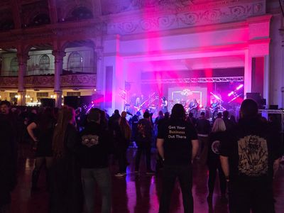 Live band performing with colorful stage lights and an engaged audience.