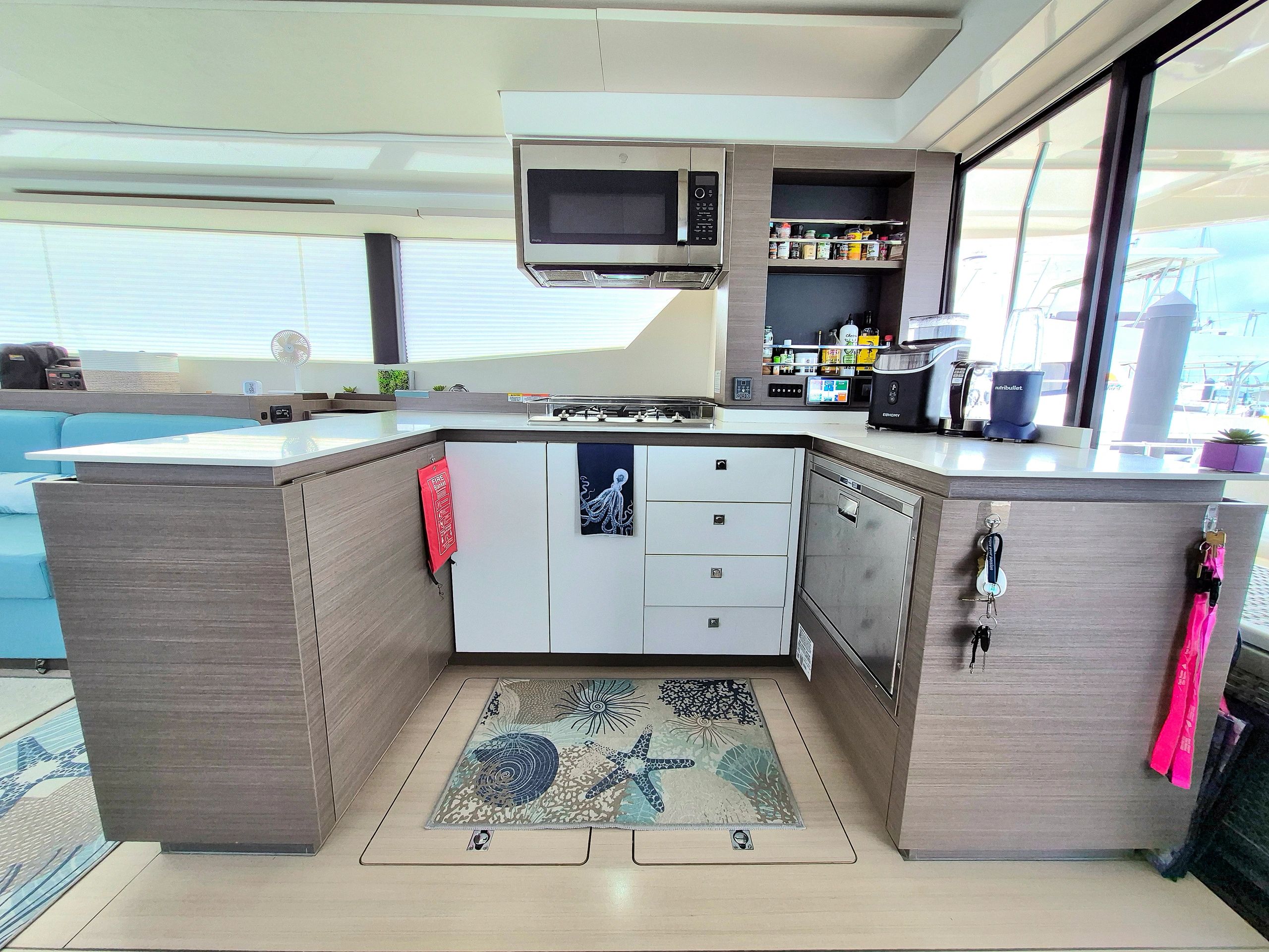 Modern yacht kitchen with microwave, stove, and spices.