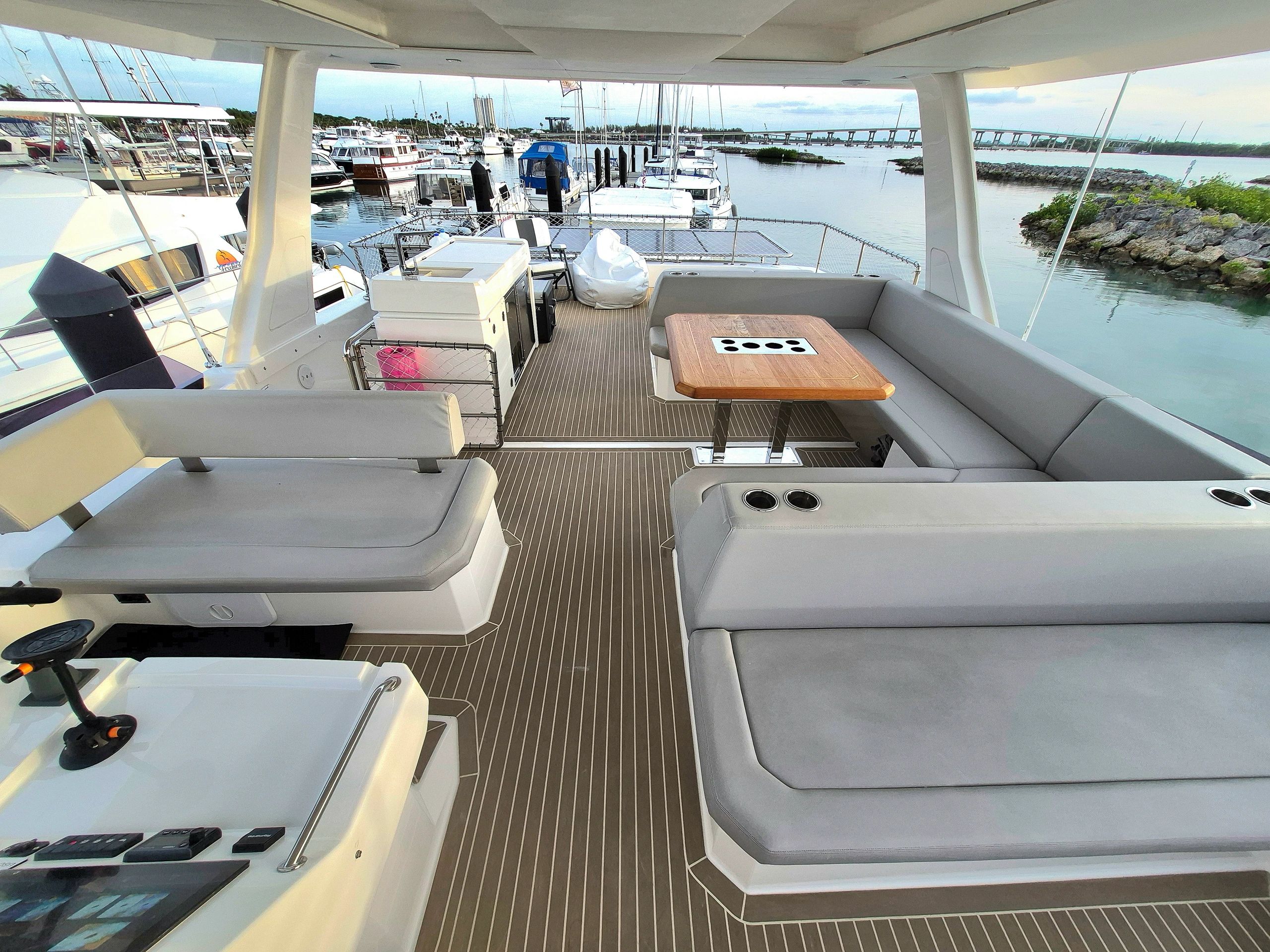 Spacious yacht deck with comfortable seating and a marina view.