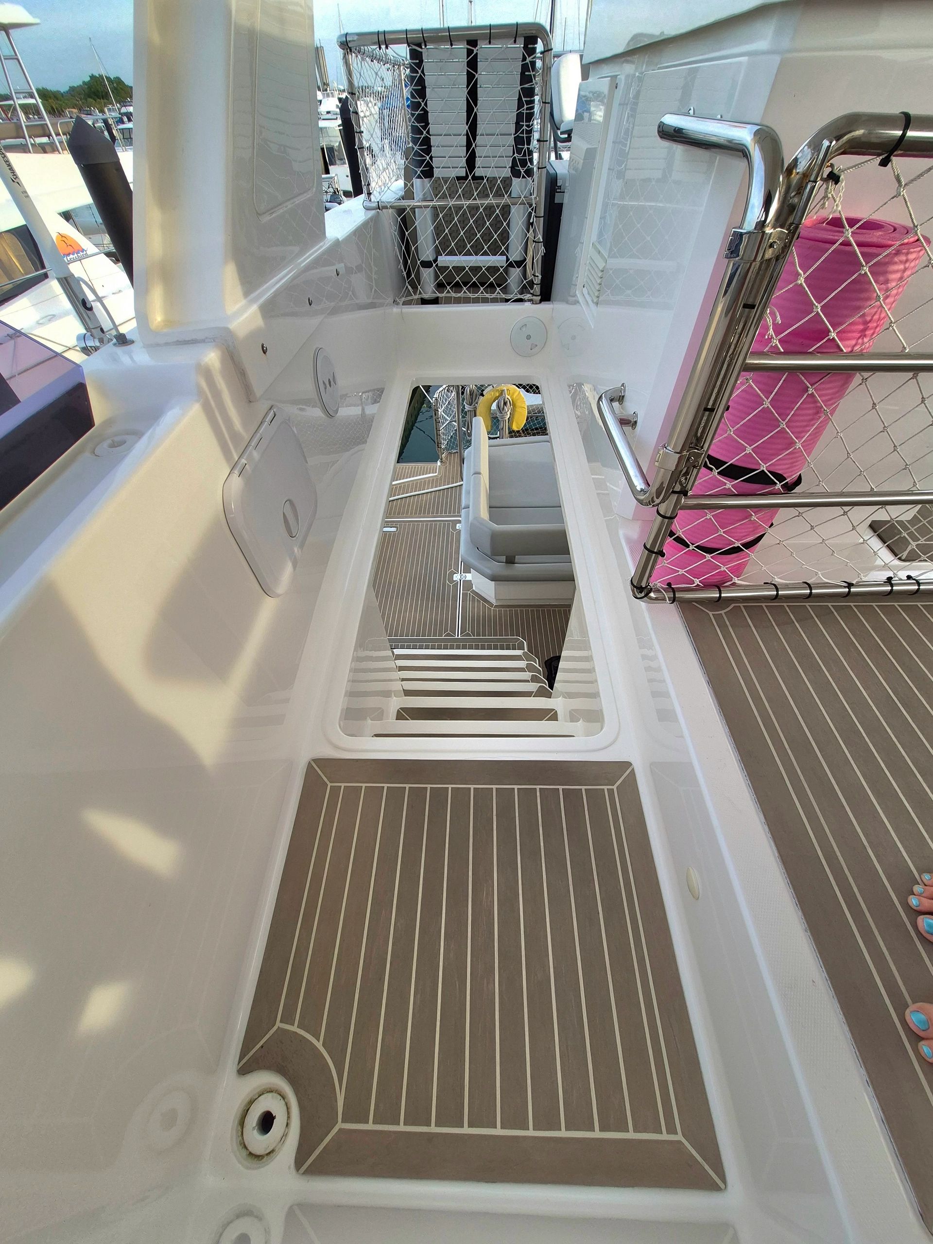 Staircase on a yacht with wood-like flooring and safety railings.