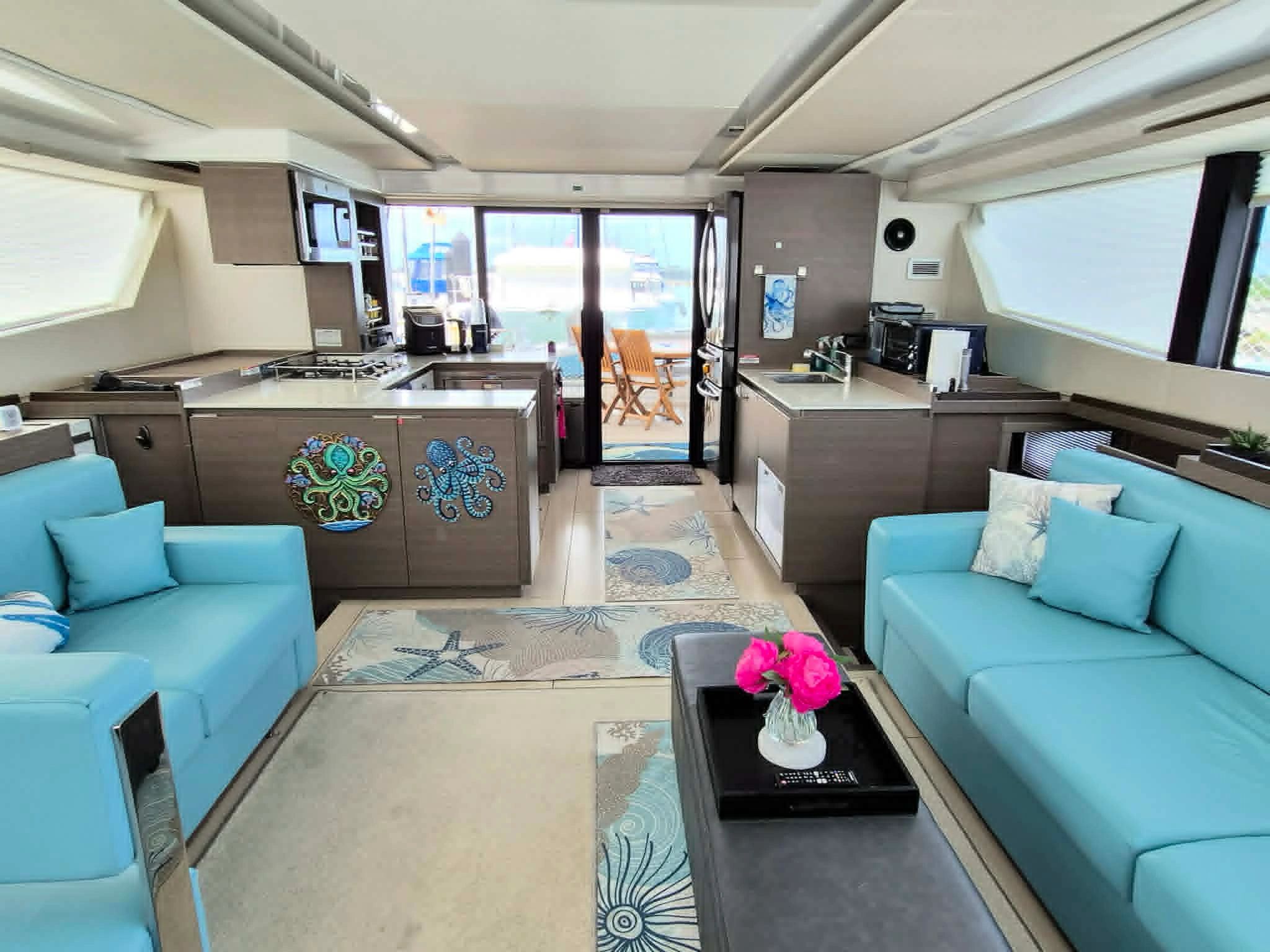 Bright, modern yacht interior with aqua sofas and sea-themed decor.