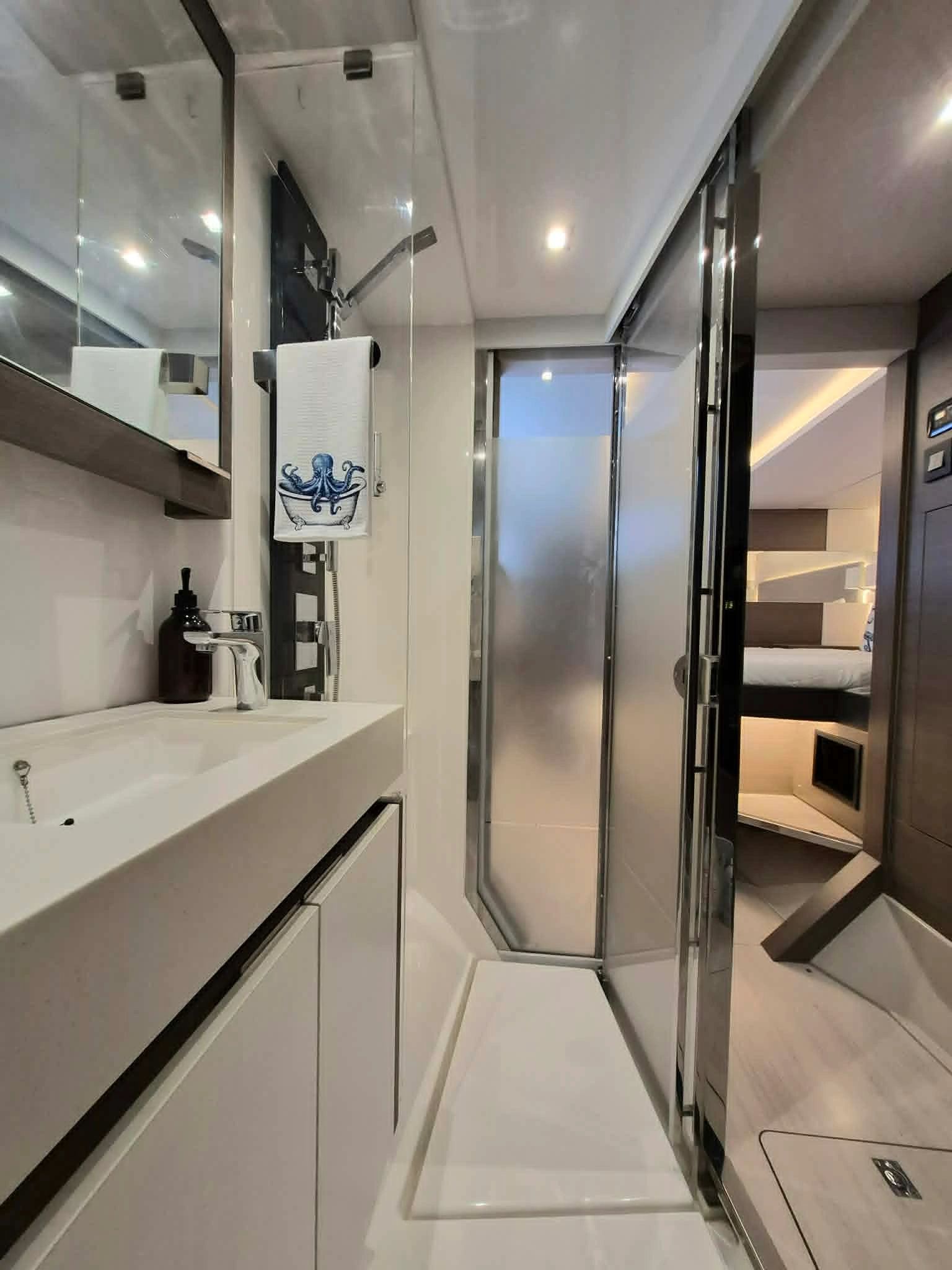 Compact modern bathroom with white fixtures and octopus-themed towel.