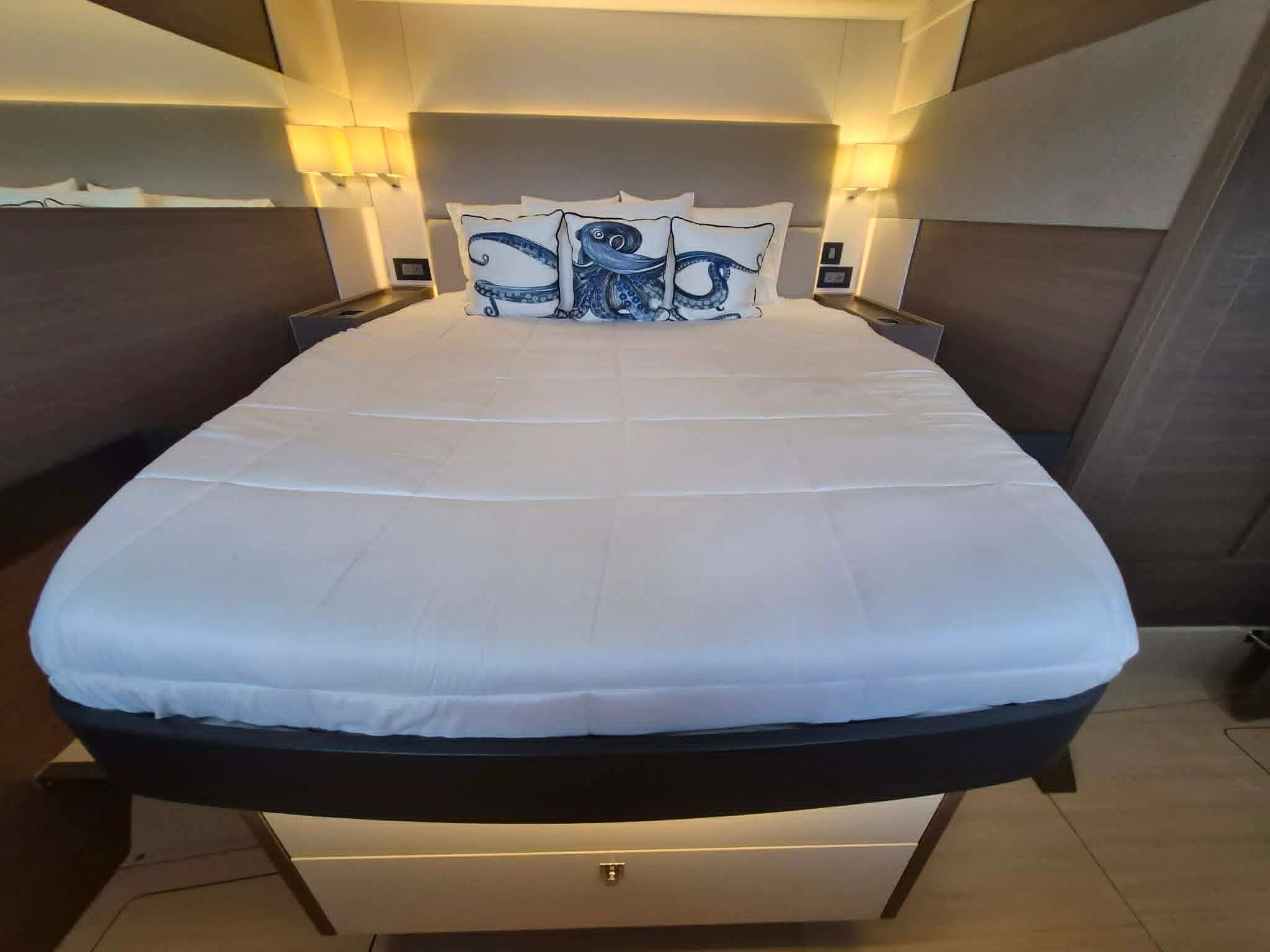 Modern bed with octopus-themed pillows and soft lighting.