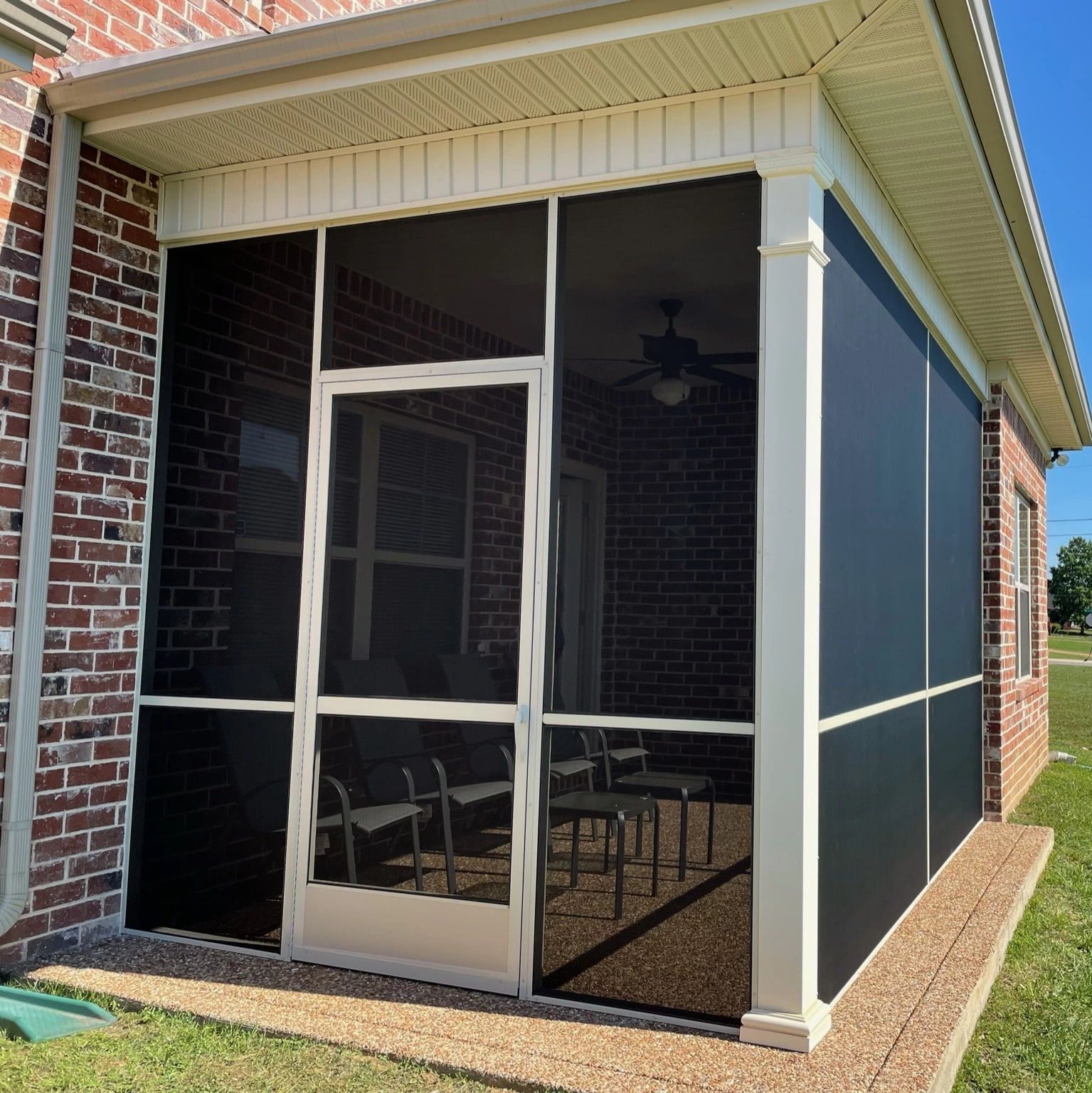 Screened porch attached to a brick house.