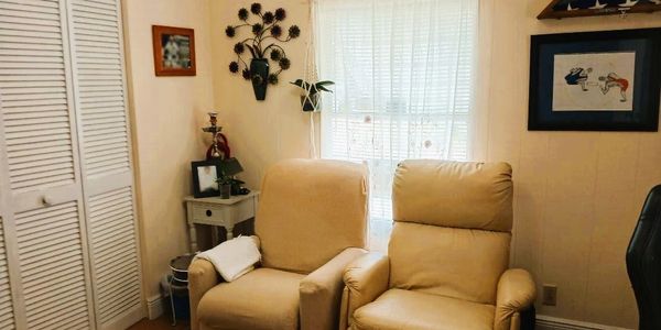 Cozy living room with two beige recliners and soft natural light.