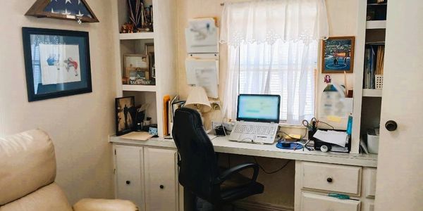 Cozy home office setup with a laptop and comfortable chair.