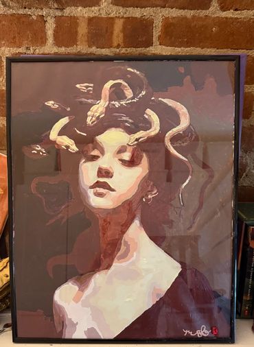 Artistic portrait of a woman with snake-like hair against a brick wall.