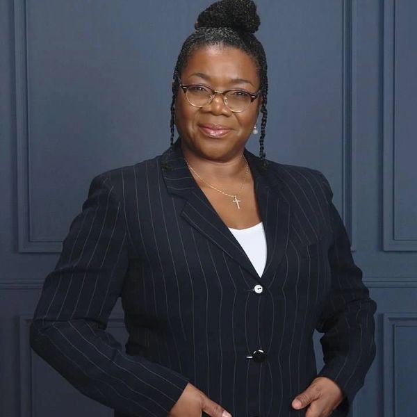 Photo of Angela E. Denmark, RPR, standing and smiling at the camera.