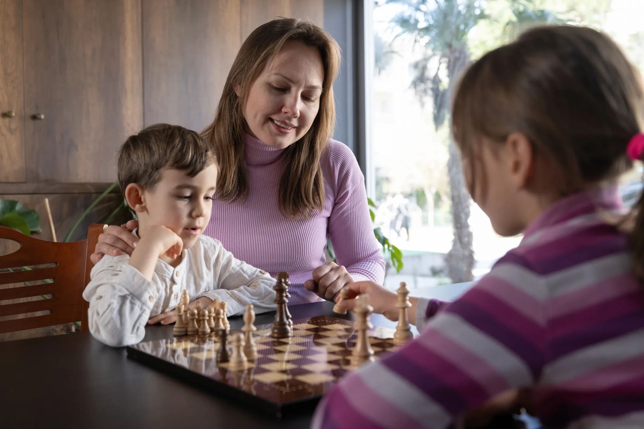 A family playing chess together indoors.