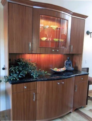 Wooden cabinet with glass display and black countertop.