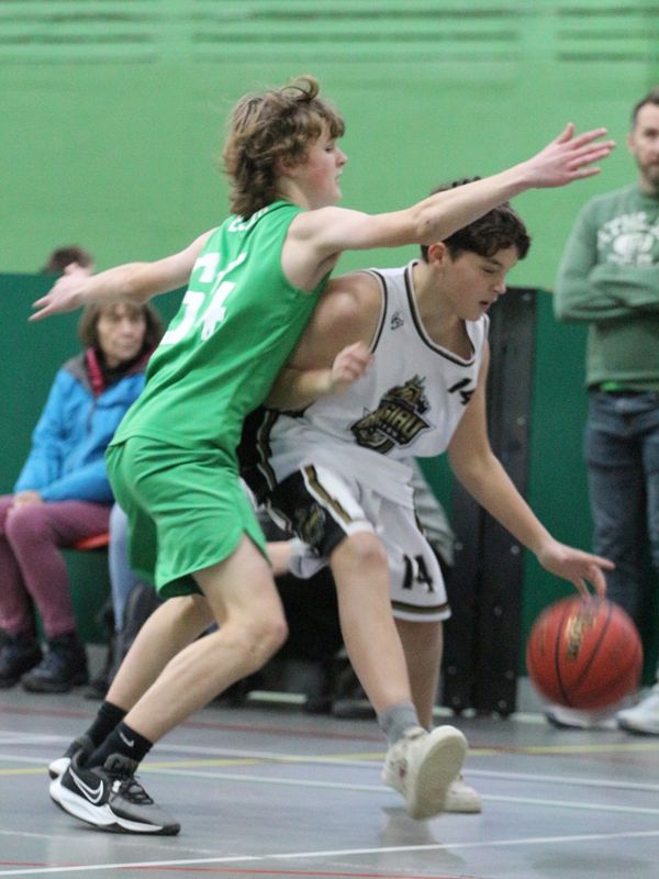 Two basketball players intensely competing for the ball on a basketball court.