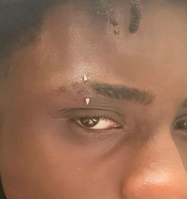 Close-up of eye with eyebrow piercings.