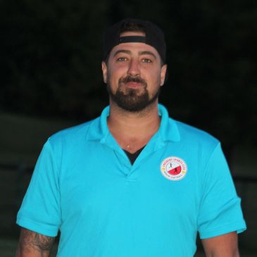 Man wearing a blue polo shirt and a black backward cap.