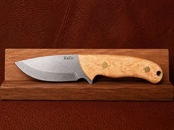 A fixed-blade knife with a wooden handle on a wooden stand.