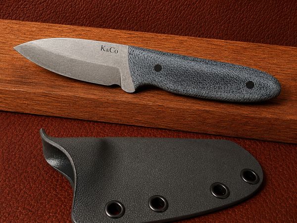 A sleek K&amp;Co fixed-blade knife with a textured handle and black sheath.