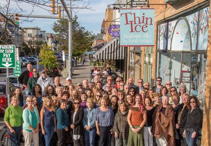 Many of the local artists of Thin Ice, over 100 pictured on the sidewalk in front of the store