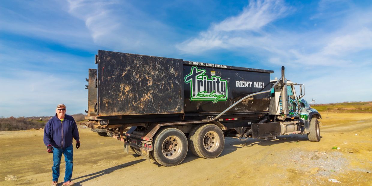 Head driver Jeff Daniels next to a Trinity Salvage roll off dumpster truck