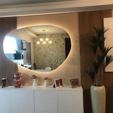 Espelho oval em decoração moderna com móveis e planta.